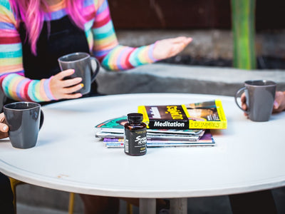 Three people drink coffee and talk about the book Meditation for Dummies around a table