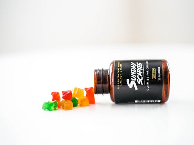 A bottle of Sunday Scaries CBD gummies is poured out on a table showing the label and whether you can be allergic to CBD edibles
