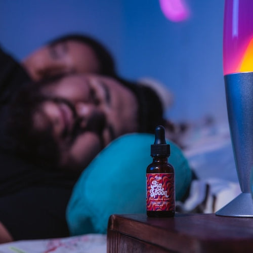 A man is sound asleep next to a bottle of Big Spoon showing the CBD oil benefits for sleep