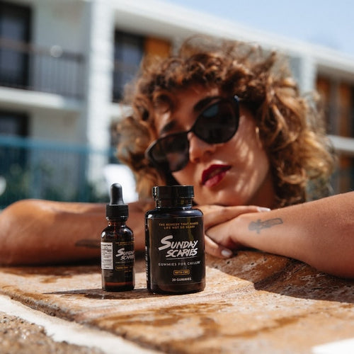 A woman in a pool compares CBD oil vs gummies next to each other
