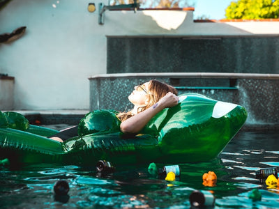 A woman lies nauseous and dizzy in a pool showing delta-9 gummies side effects
