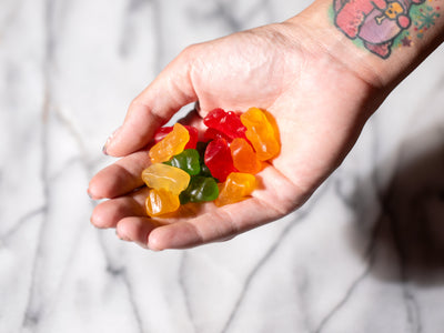 A woman holds a bunch of CBD gummies in her palm showing whether they have THC or not
