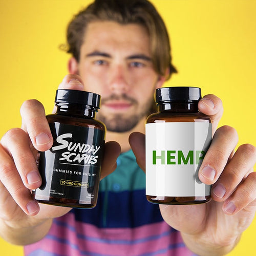 A man holds up two bottles showing hemp gummies vs. CBD gummies and what the difference is