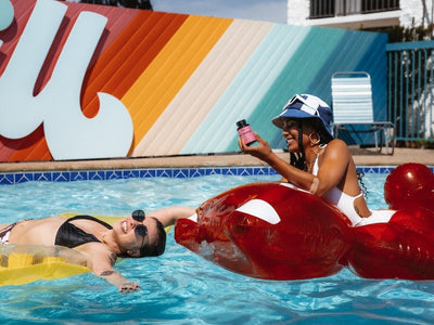 Two woman relax in the pool looking calm and happy, showing how CBD gummies make you feel