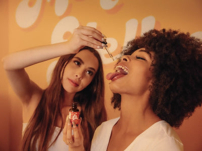 A female drops some Big Spoon in her girlfriend's mouth showing how long CBD oil takes to work for sleep