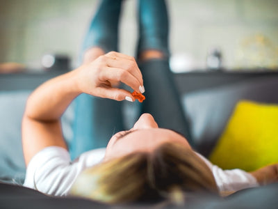A woman lays back on her bed contemplating how long Delta-9 gummies last