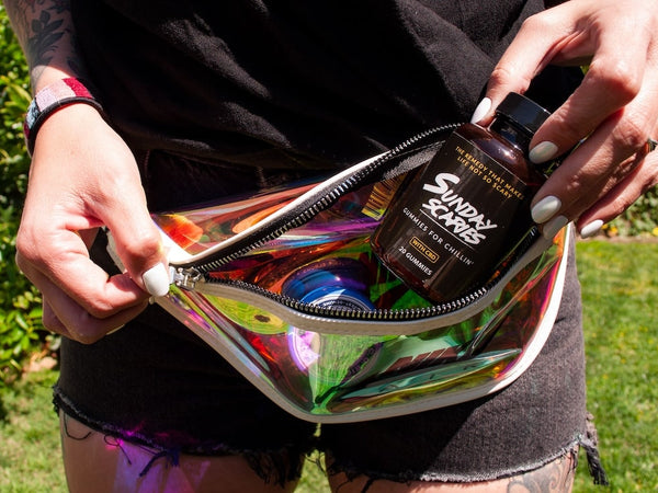 A woman takes a bottle of Sunday Scaries out of her fanny pack showing how to take CBD gummies