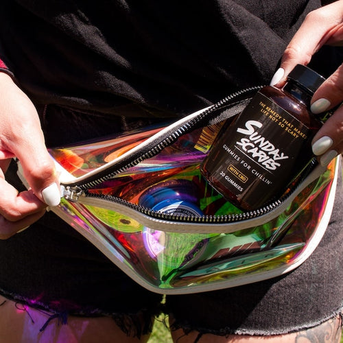 A woman takes a bottle of Sunday Scaries out of her fanny pack showing how to take CBD gummies