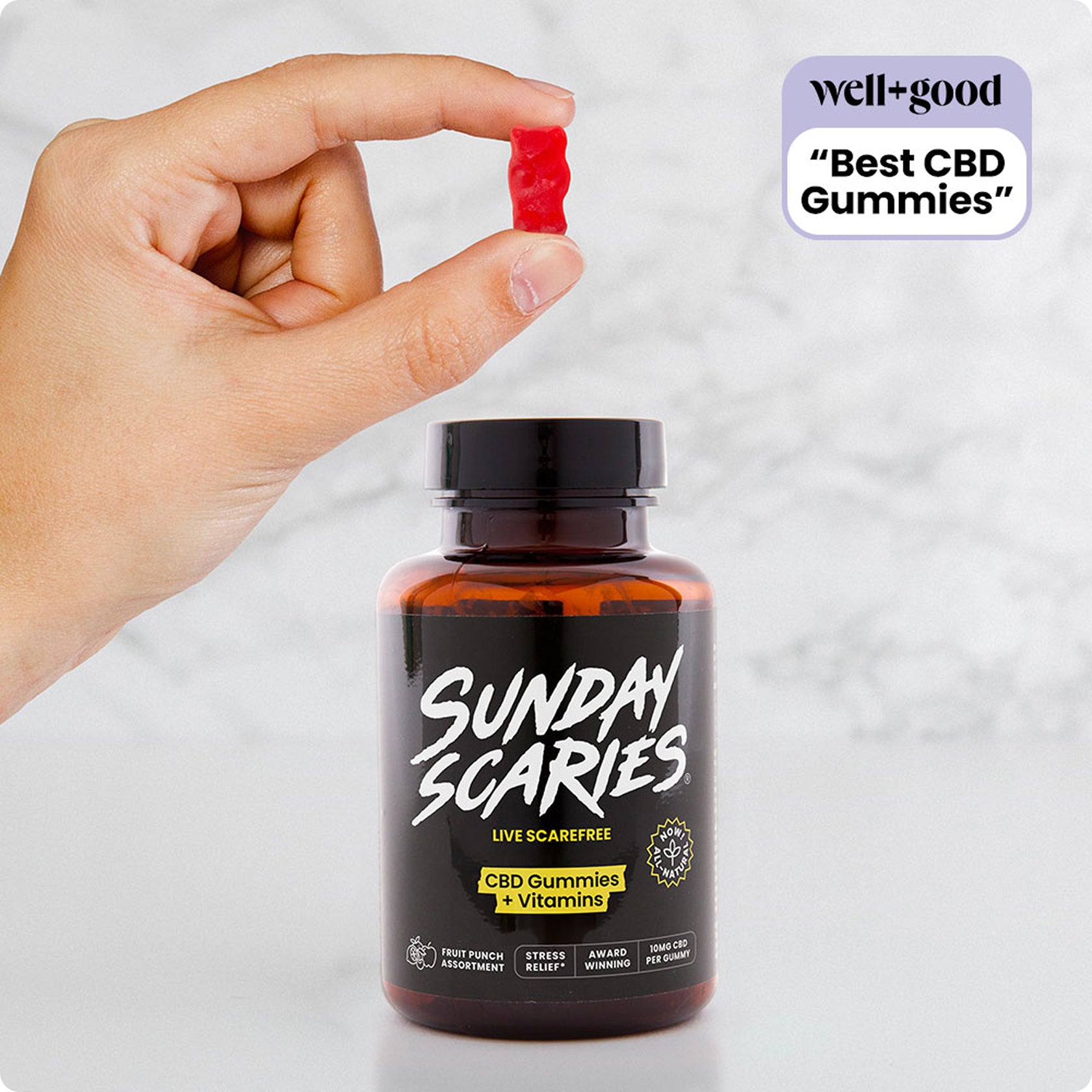 Bottle of Sunday Scaries CBD Gummies with a hand holding a gummy, on a light background.