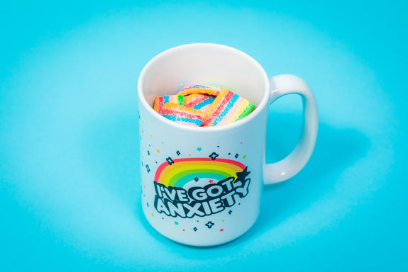 A coffee mug that has "I've Got Anxiety" on the side is filled Sunday Scaries Unicorn Jerky CBD Candies