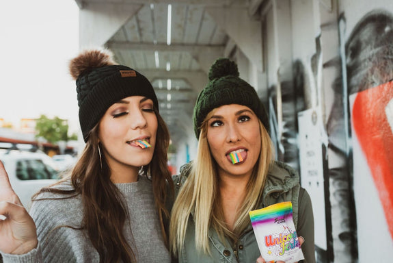 Two girls embrace self-expression by making funny faces and eating Unicorn Jerky