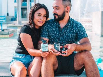 A couple sits down together holding Sunday Scaries products while the male looks at his girlfriend