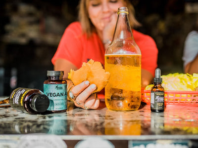 A female eats a burger and drinks a beer next to her CBD products