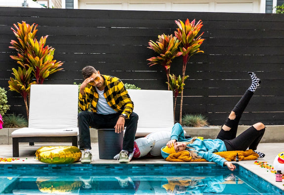 A man and woman are hungover by the pool
