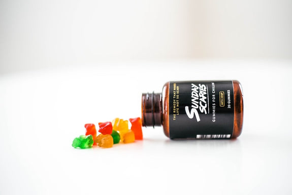 A bottle of Sunday Scaries CBD gummies is poured out on a table showing the label and whether you can be allergic to CBD edibles