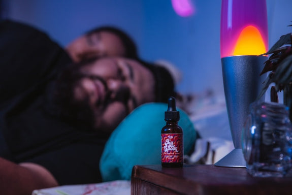 A man is sound asleep next to a bottle of Big Spoon showing the CBD oil benefits for sleep