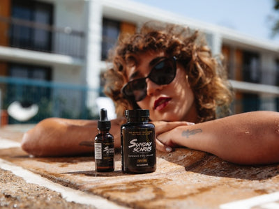 A woman in a pool compares CBD oil vs gummies next to each other