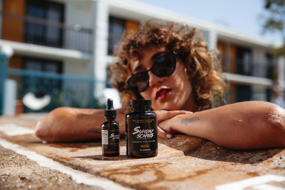 A woman in a pool compares CBD oil vs gummies next to each other