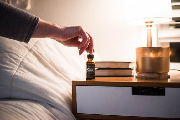 A man grabs a bottle of Sunday Scaries on his nightstand showing CBD vs THC for Sleep and which is better