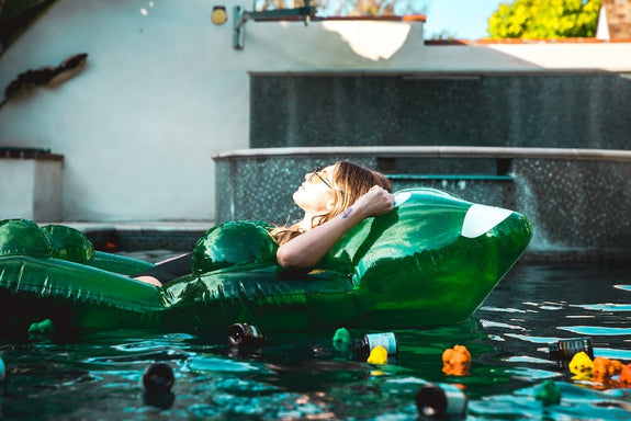 A woman lies nauseous and dizzy in a pool showing delta-9 gummies side effects