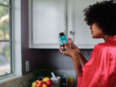 A woman checks the back of the label of Vegan AF in front of her cabinet to check when CBD gummies expire
