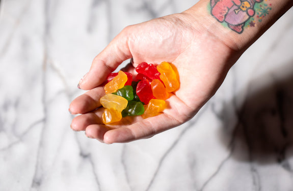 A woman holds a bunch of CBD gummies in her palm showing whether they have THC or not