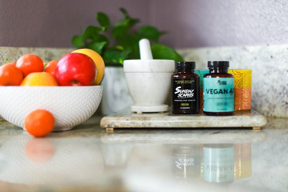 Sunday Scaries products on a kitchen counter next to a bowl of fruit showing that CBD does not make you hungry