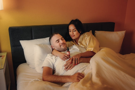 A wife gives her husband a sleep oil showing how CBD makes you tired