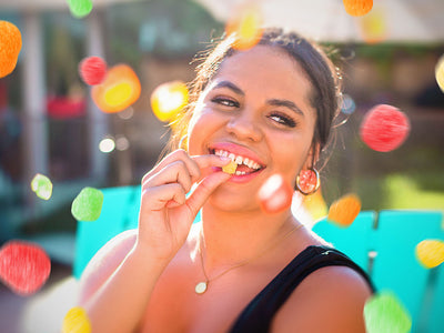 A happy woman eating a CBD gummy showing what CBD feels like