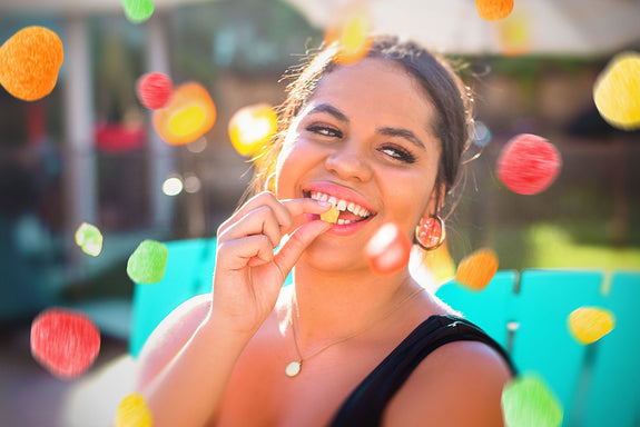 A happy woman eating a CBD gummy showing what CBD feels like