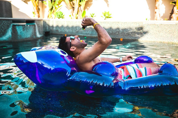 A guy chills on a raft in the pool eating Sunday Scaries and showing how THC gummies make you feel