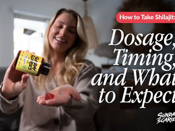 A woman sits on her couch and pours two shilajit gummies into her hand. 