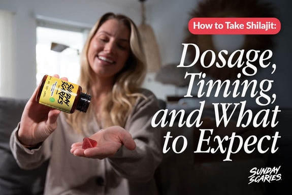 A woman sits on her couch and pours two shilajit gummies into her hand. 