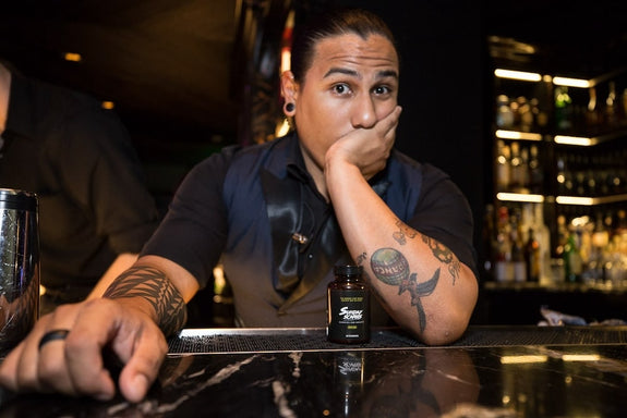 A bartender next to a bottle of Sunday Scaries questions how long THC from CBD gummies stays in your system