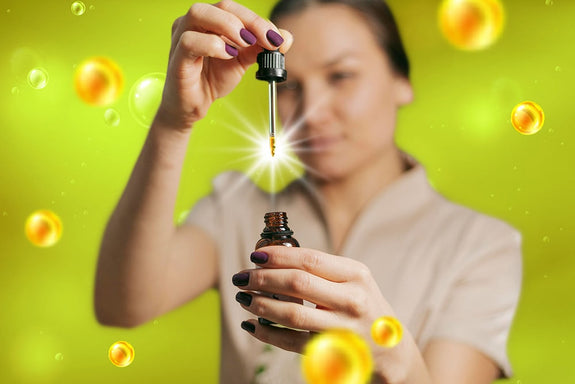 A woman lifting a pipette out of a vial while showing what CBD is