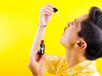 A man drops a pipette of CBG oil in his mouth showing how to use CBG (Cannabigerol)