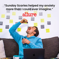 Man in blue sweatshirt sitting on a couch with a laptop, surrounded by sticky notes, with text about 'Sunday Scaries' and a quote from Allure: 