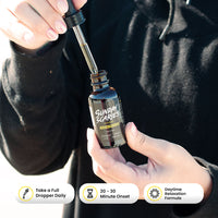 Bottle of 'Sunday Scaries' CBD oil with a dropper, held by a person wearing a black hoodie along with icons for how it works