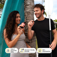 A couple in front of a paddle board and palm tree look at the Sunday Scaries mushroom gummy and bottle with ingredient call outs listed below it